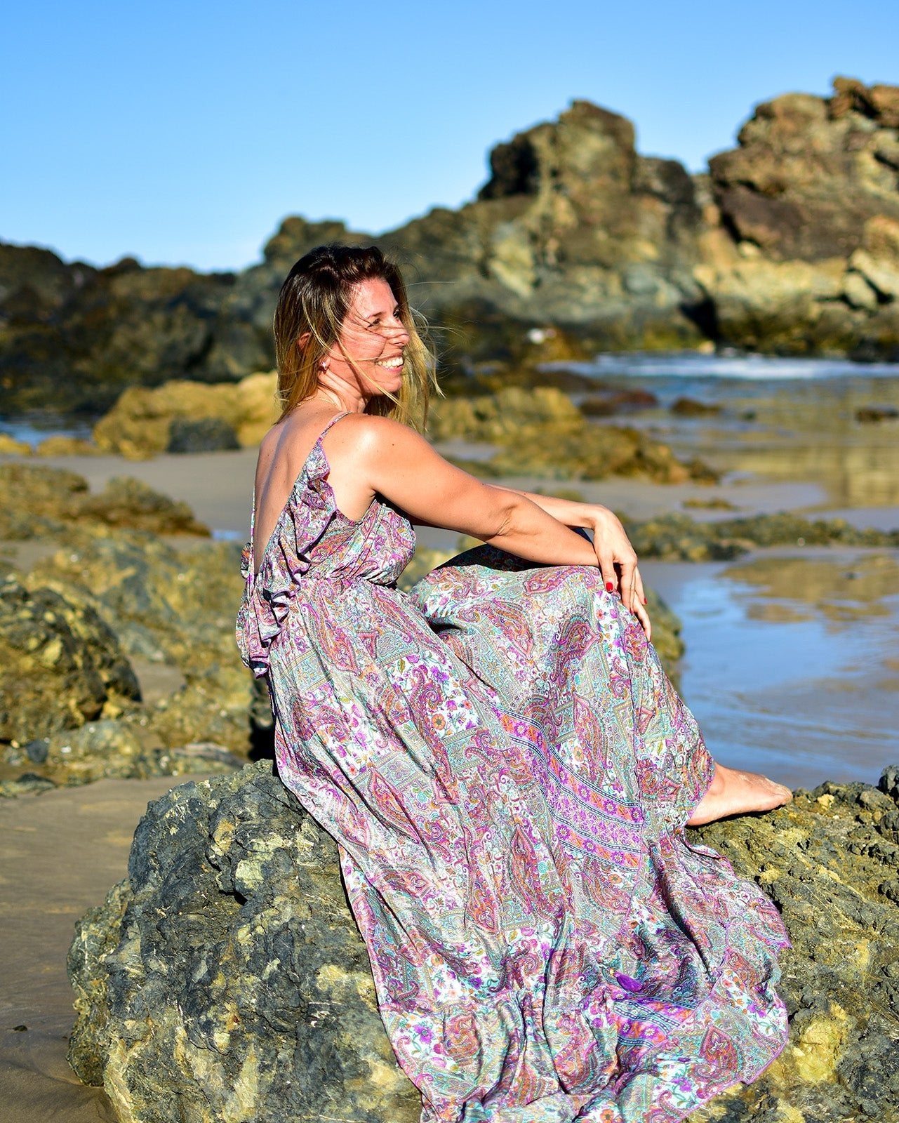 Noosa Maxi Dress featuring a vibrant paisley print in purple, teal, and blush with adjustable straps