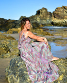 Noosa Maxi Dress featuring a vibrant paisley print in purple, teal, and blush with adjustable straps