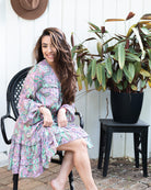 Nova Midi Dress showcasing a vibrant paisley print in lilac and green with long sleeves